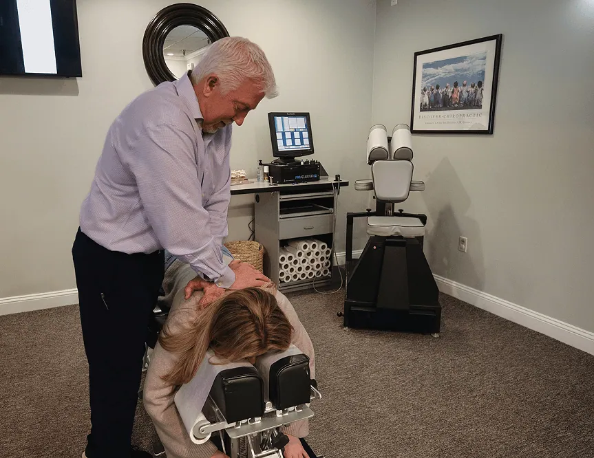 Dr. Mark Arsenault giving the woman a back pain treatment