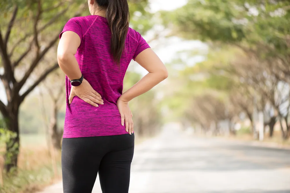 woman having a back pain after her jogging