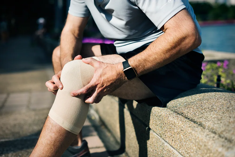 man suffering from knee pain after work out