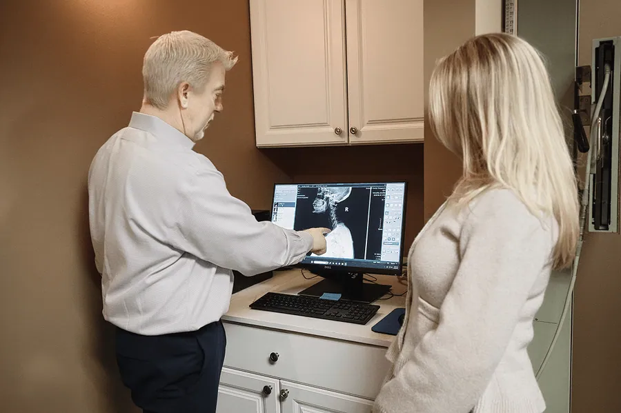 Dr. Mark Arsenault reviewing a spine x-ray with a patient