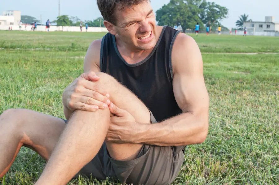 Athlete holding his knee after a strain