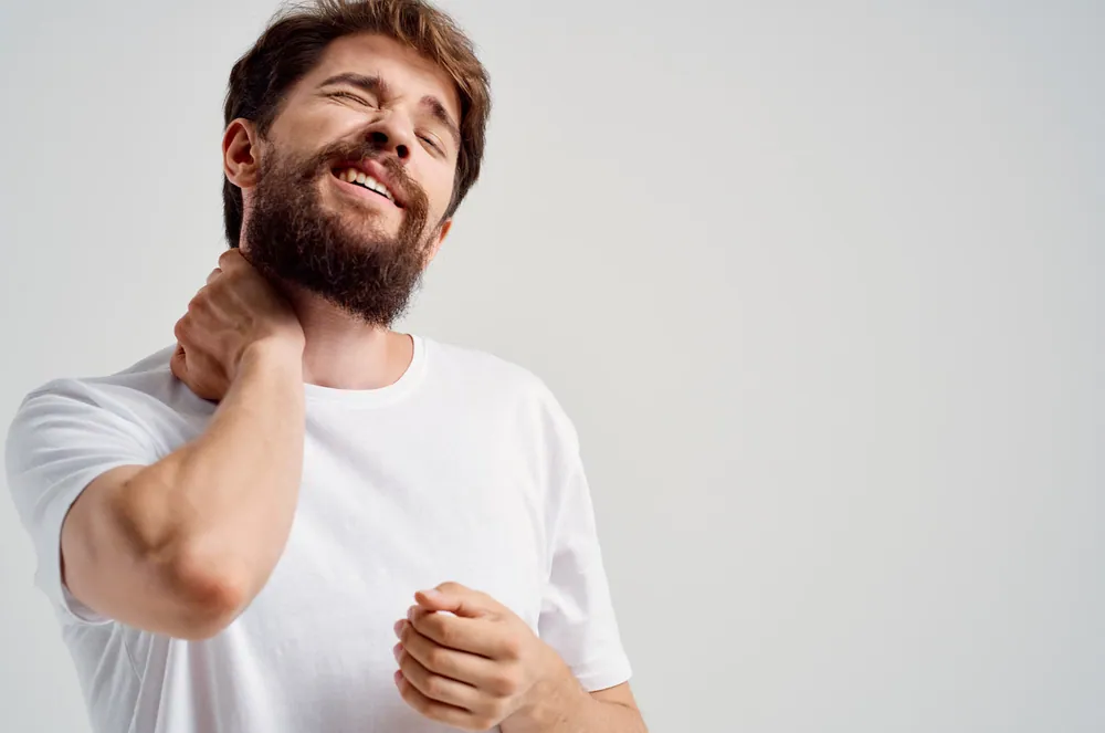 man suffering from neck pain